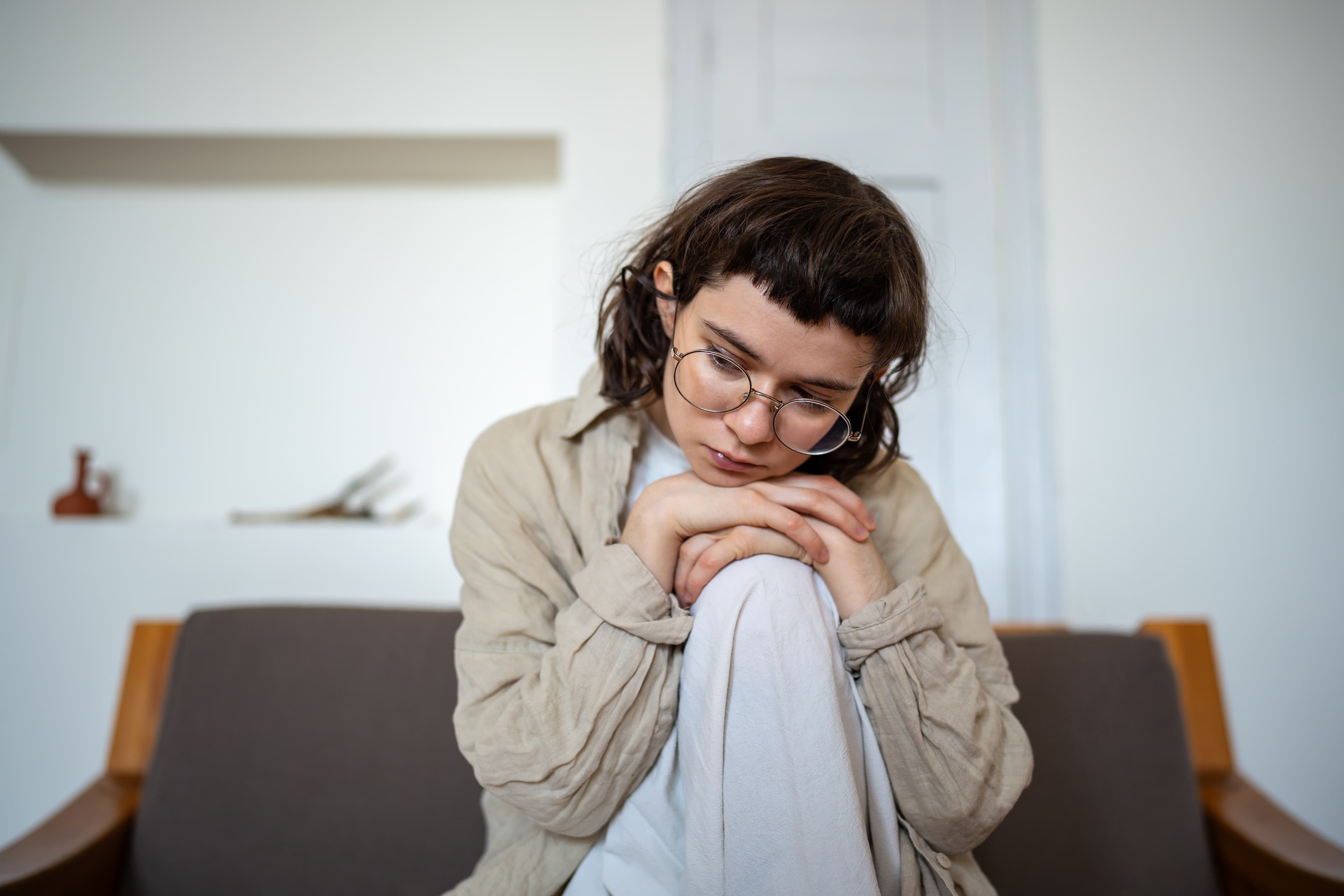 Junge Frau, nachdenklich, allein sitzend