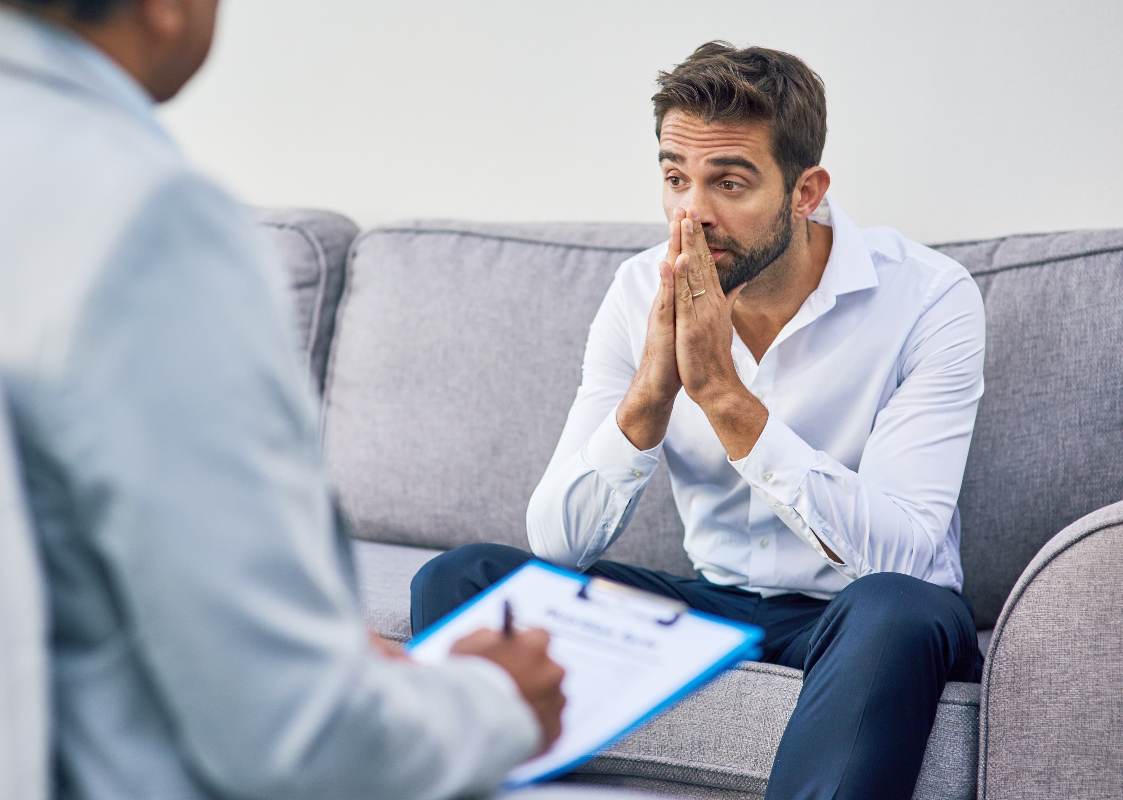Mann in emotional aufgewühltem Gespräch mit einer Fachperson