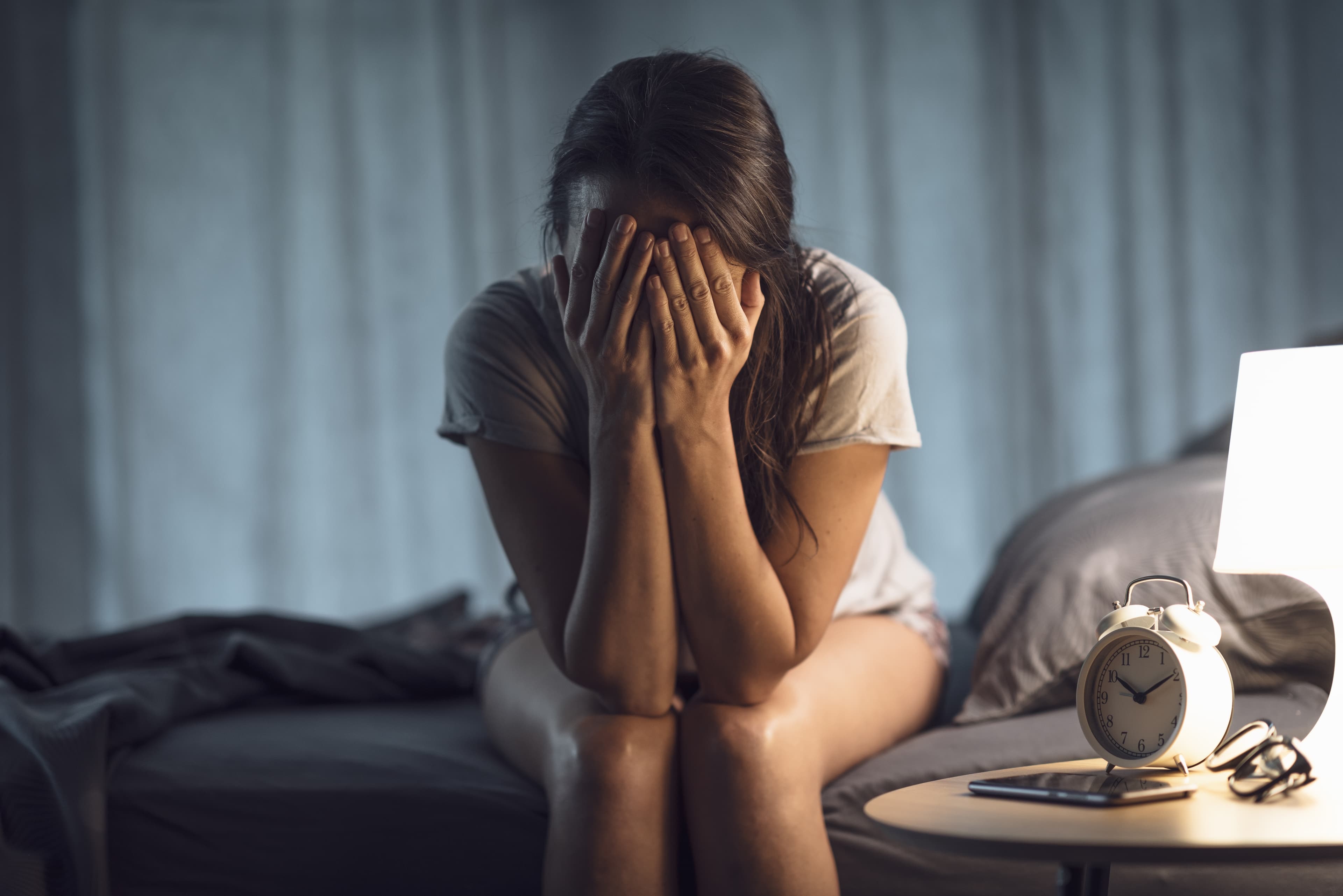 Frau sitzt allein und nachdenklich, nachts wach