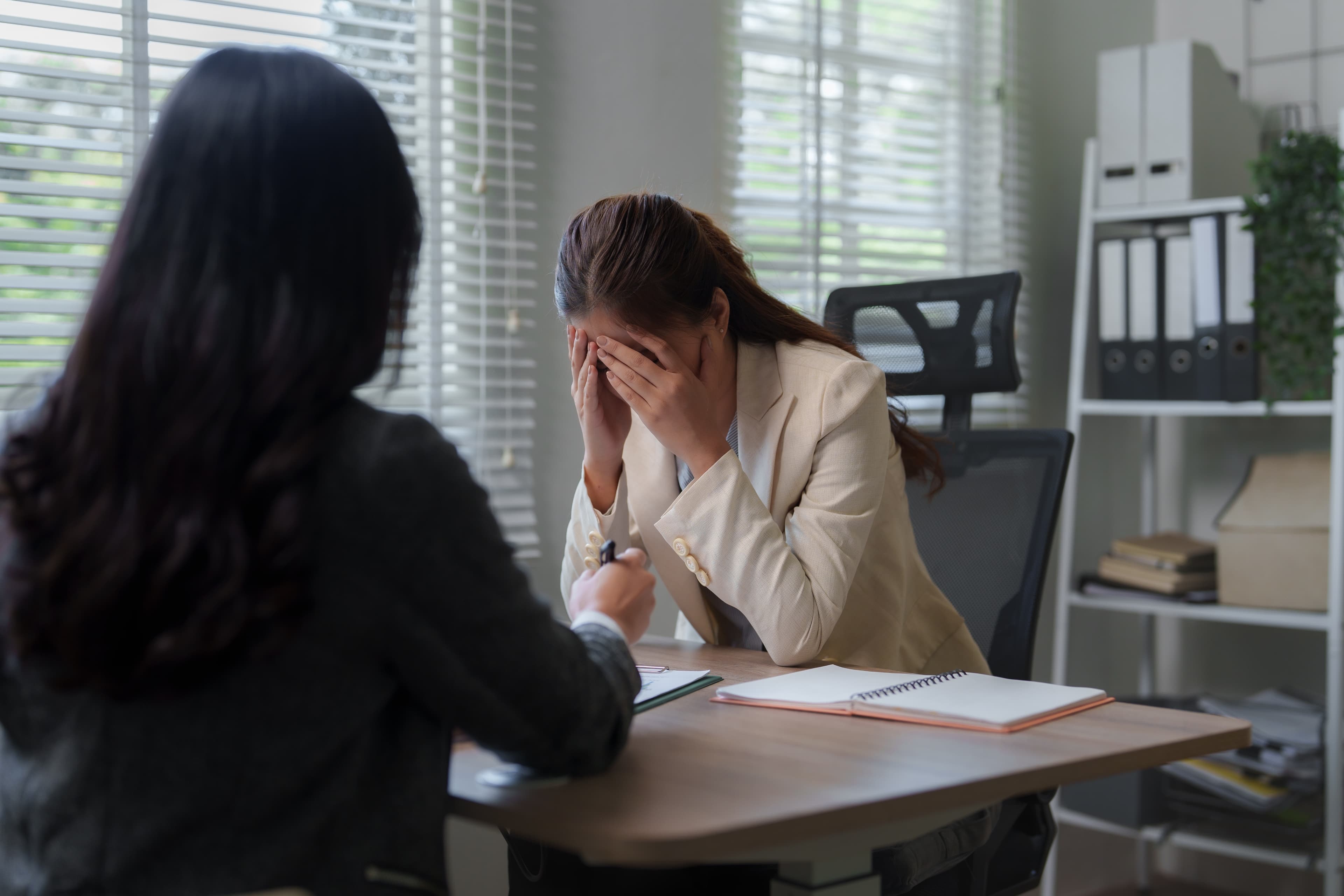 Frau mit belasteter Miene am Arbeitsplatz im Gespräch